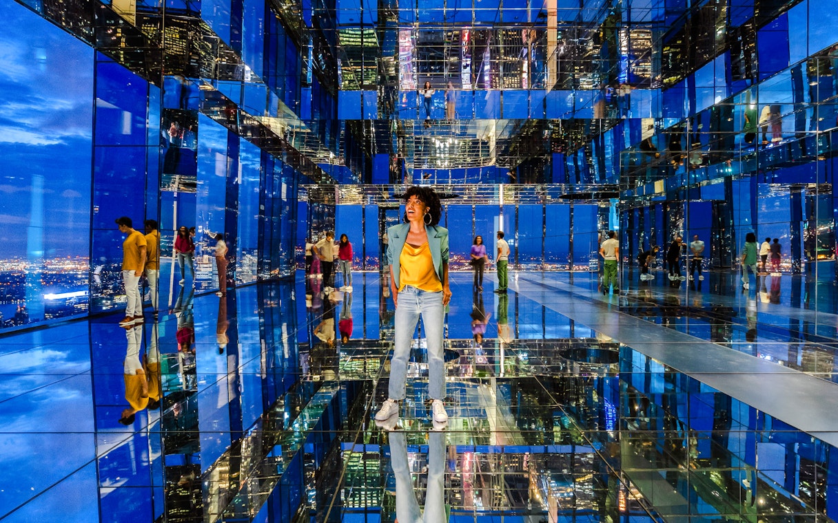 Guests exploring mirrored observatory at Summit One Vanderbilt at night.