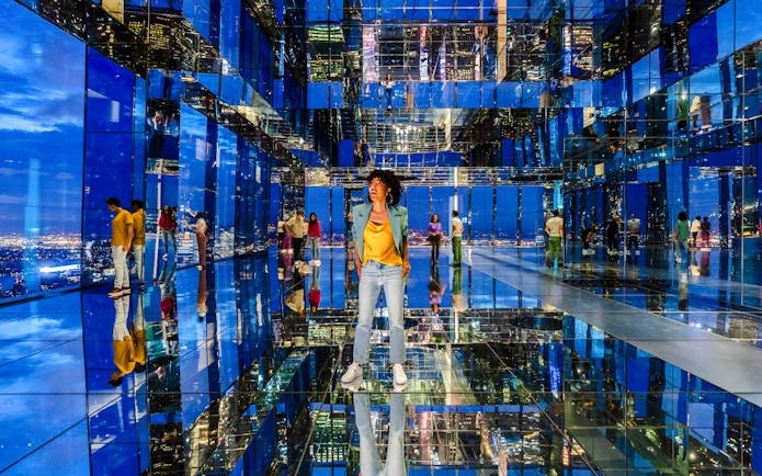 Guests exploring mirrored observatory at Summit One Vanderbilt at night.
