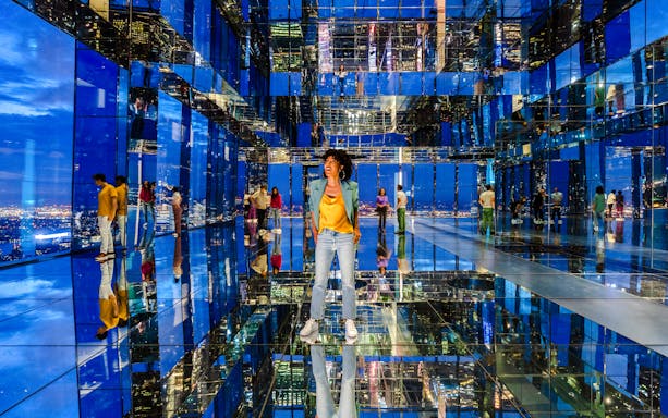 Guests exploring mirrored observatory at Summit One Vanderbilt at night.