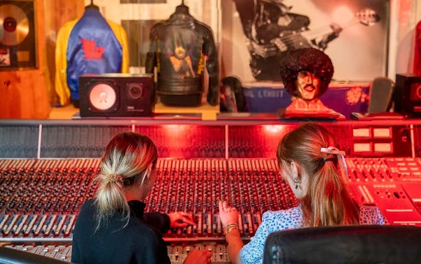 Recording studio at Irish Rock N Roll Museum Experience with visitors at soundboard.