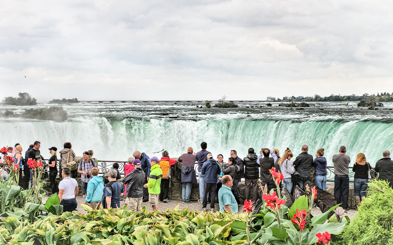 Tourists viewing Niagara Falls from a lookout point in Canada.
