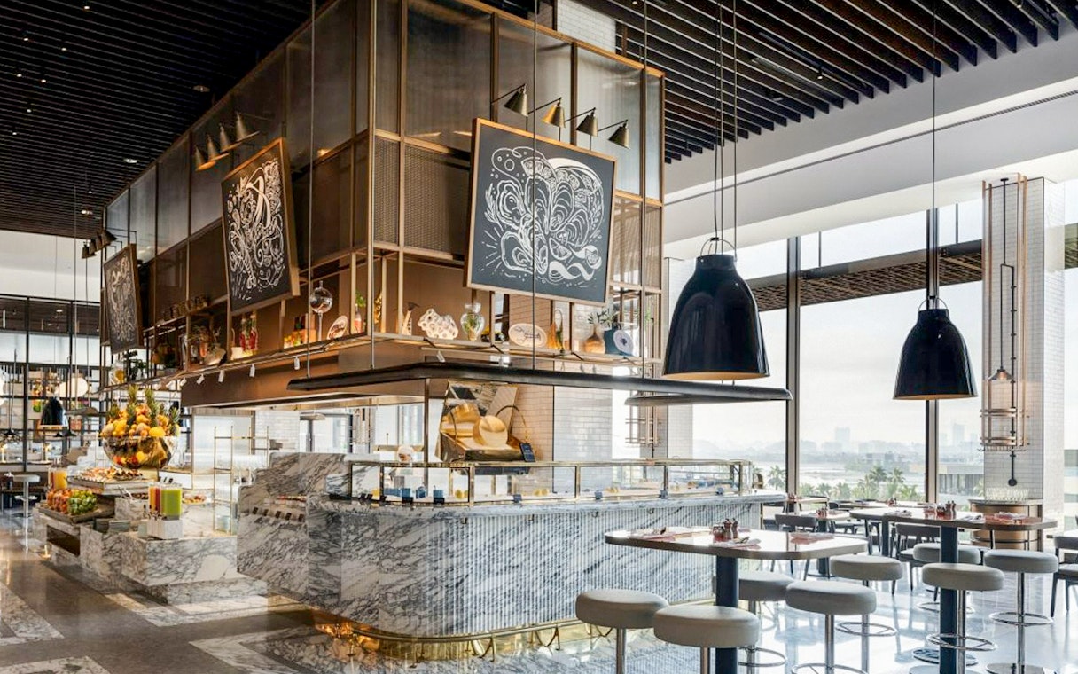 Dining area at Gastronomy, Dubai with marble counters and modern decor.
