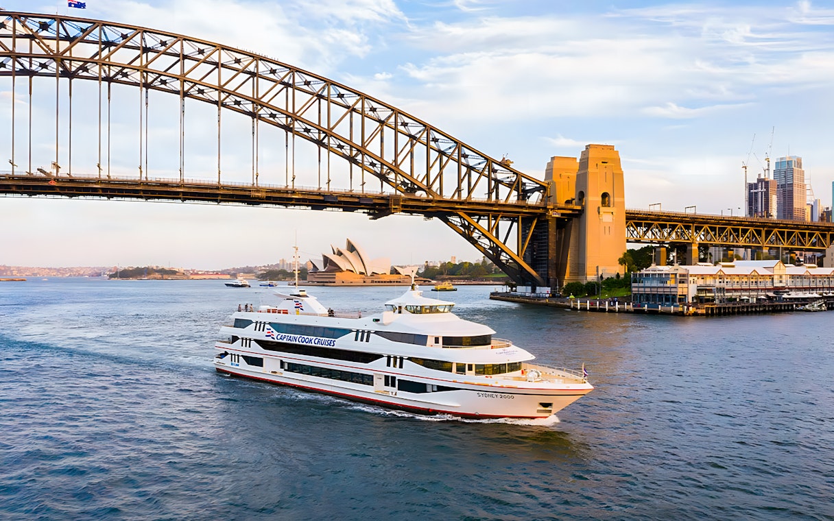 Cruise ship on Sydney Harbour near Sydney Opera House and Harbour Bridge.