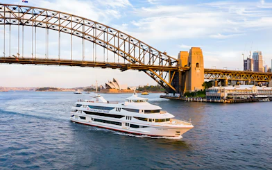 Cruise ship on Sydney Harbour near Sydney Opera House and Harbour Bridge.