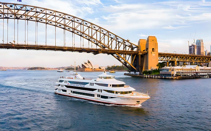 Cruise ship on Sydney Harbour near Sydney Opera House and Harbour Bridge.