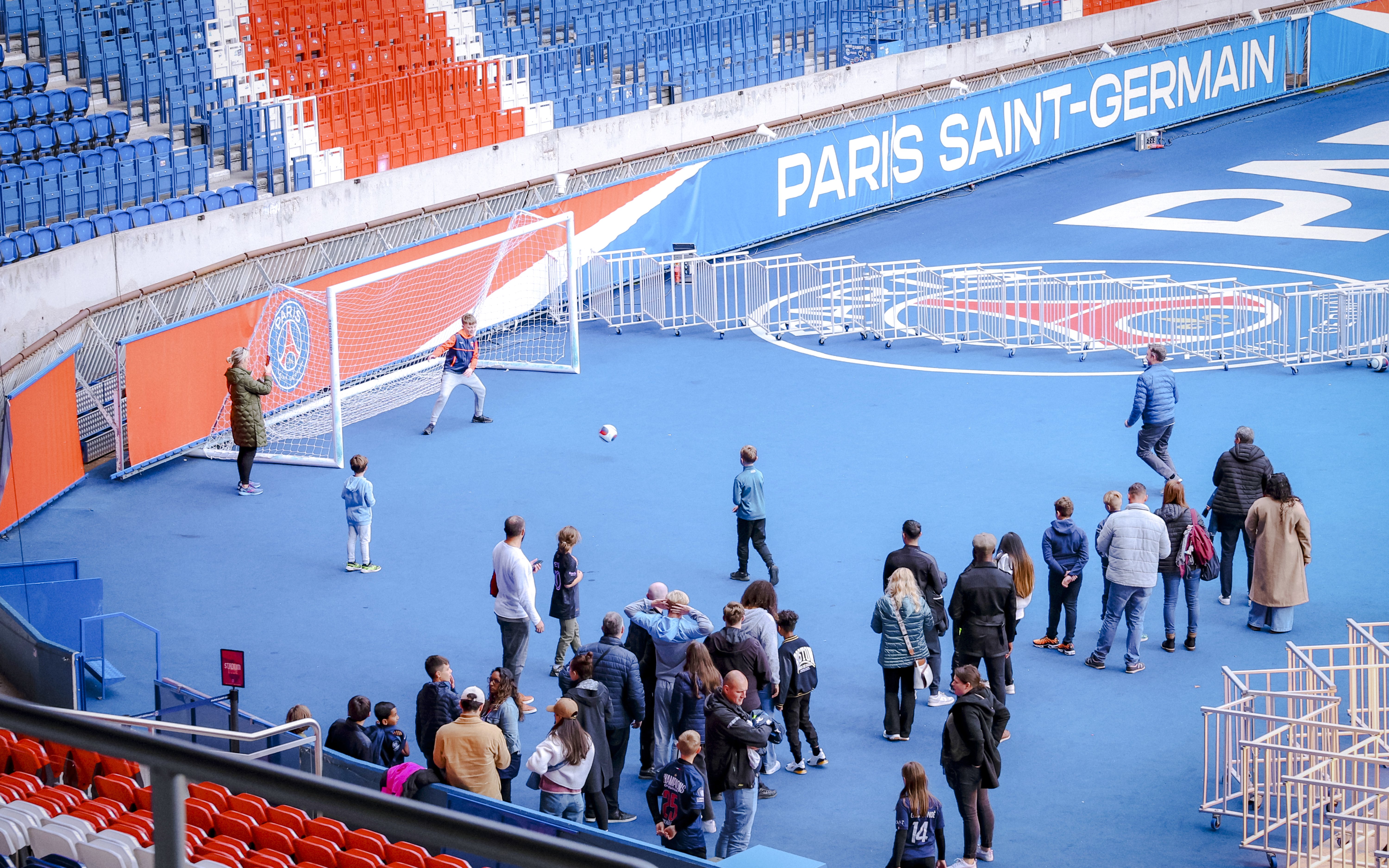 Visitors playing soccer on the field at PSG Stadium, Paris, France.