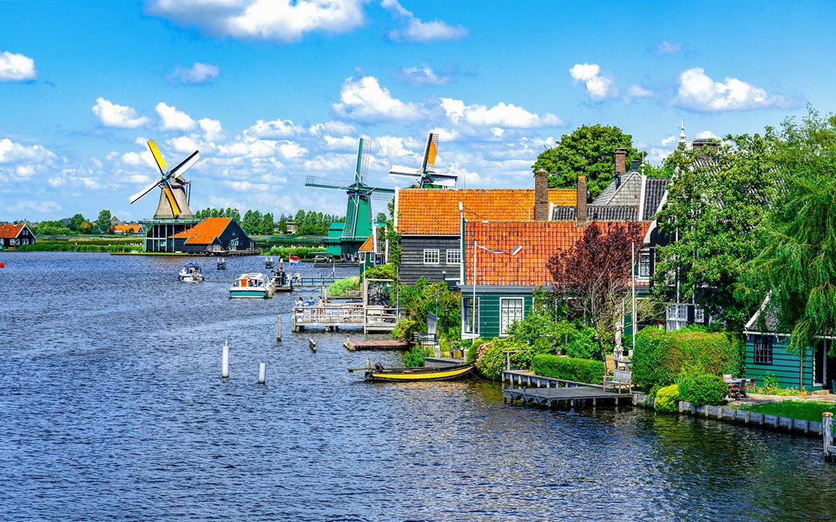Windmills and traditional houses along the water in Zaanse Schans, Holland.