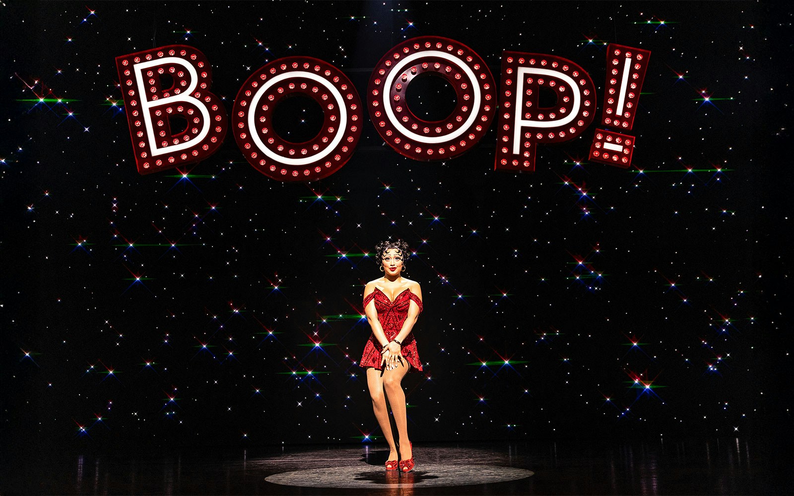 Performer in red dress under "BOOP!" sign in Betty Boop Musical.