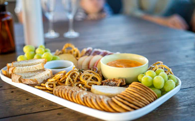 Platter of bread, pretzels, grapes, and dip on a table during Top End Safari Camp tour near Finniss River.