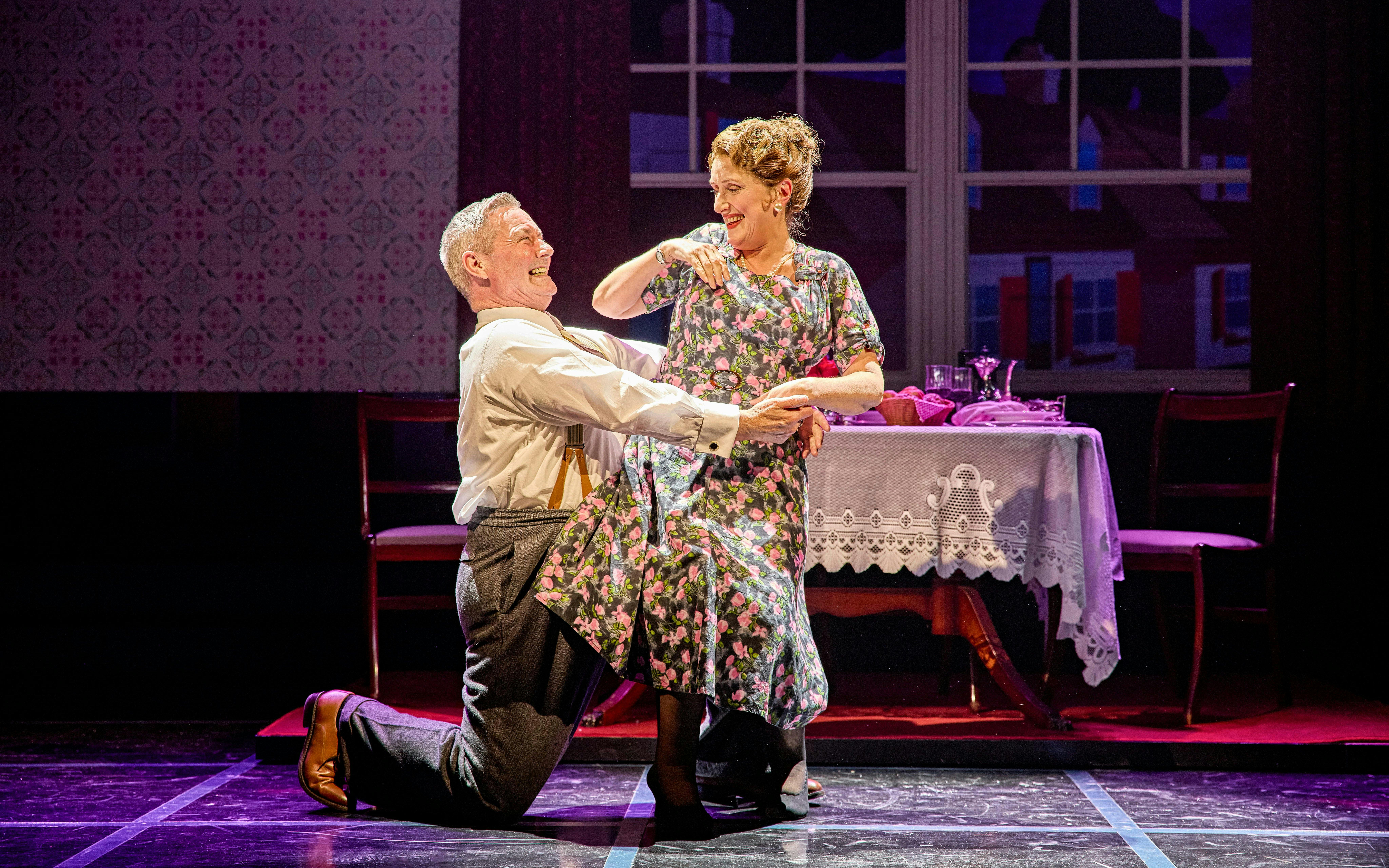 Couple dancing in a scene from Sinatra The Musical, Westend, with a dining table in the background.