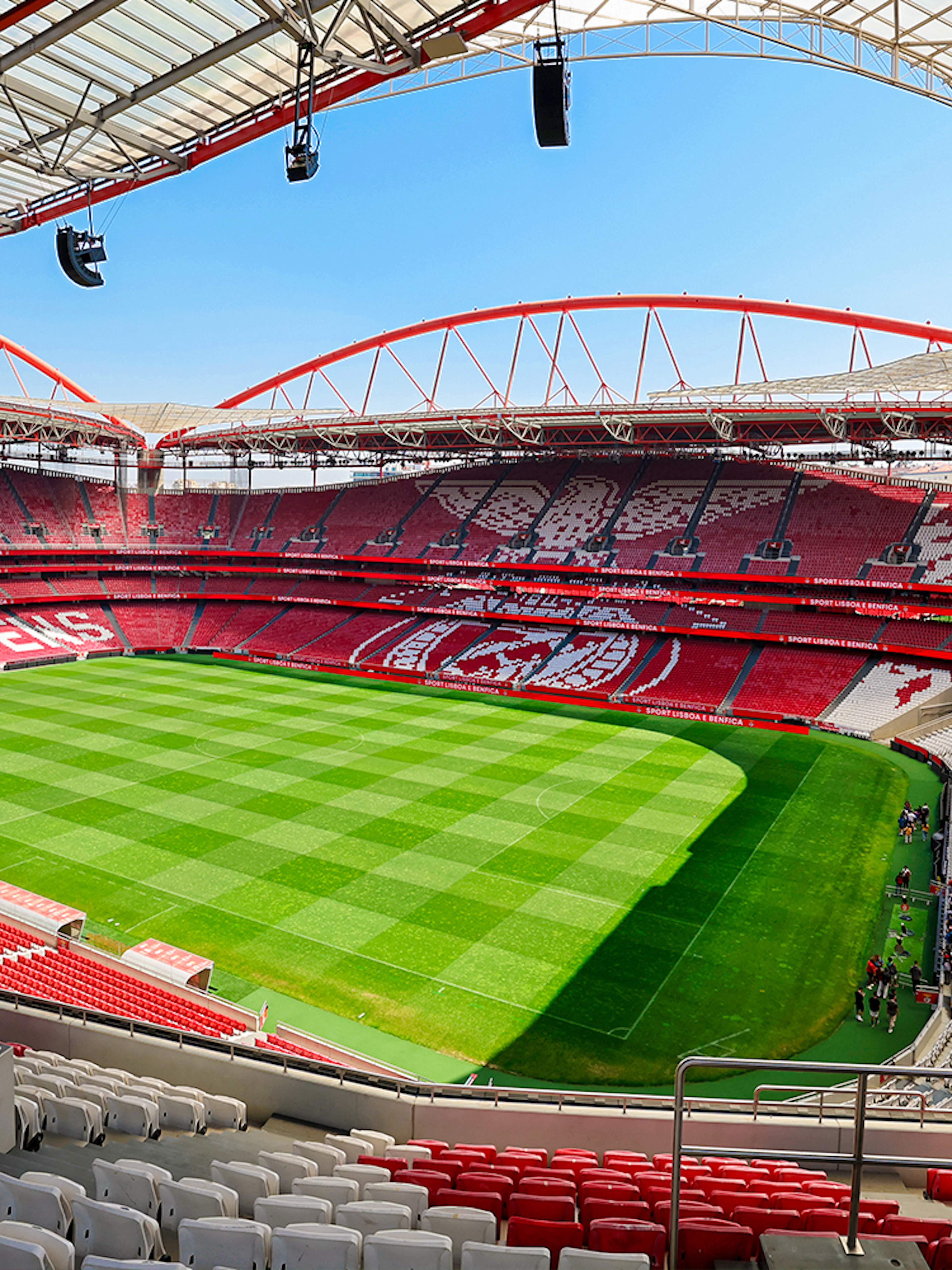 Benfica Stadium view from spectator stand showing green field and red seating.