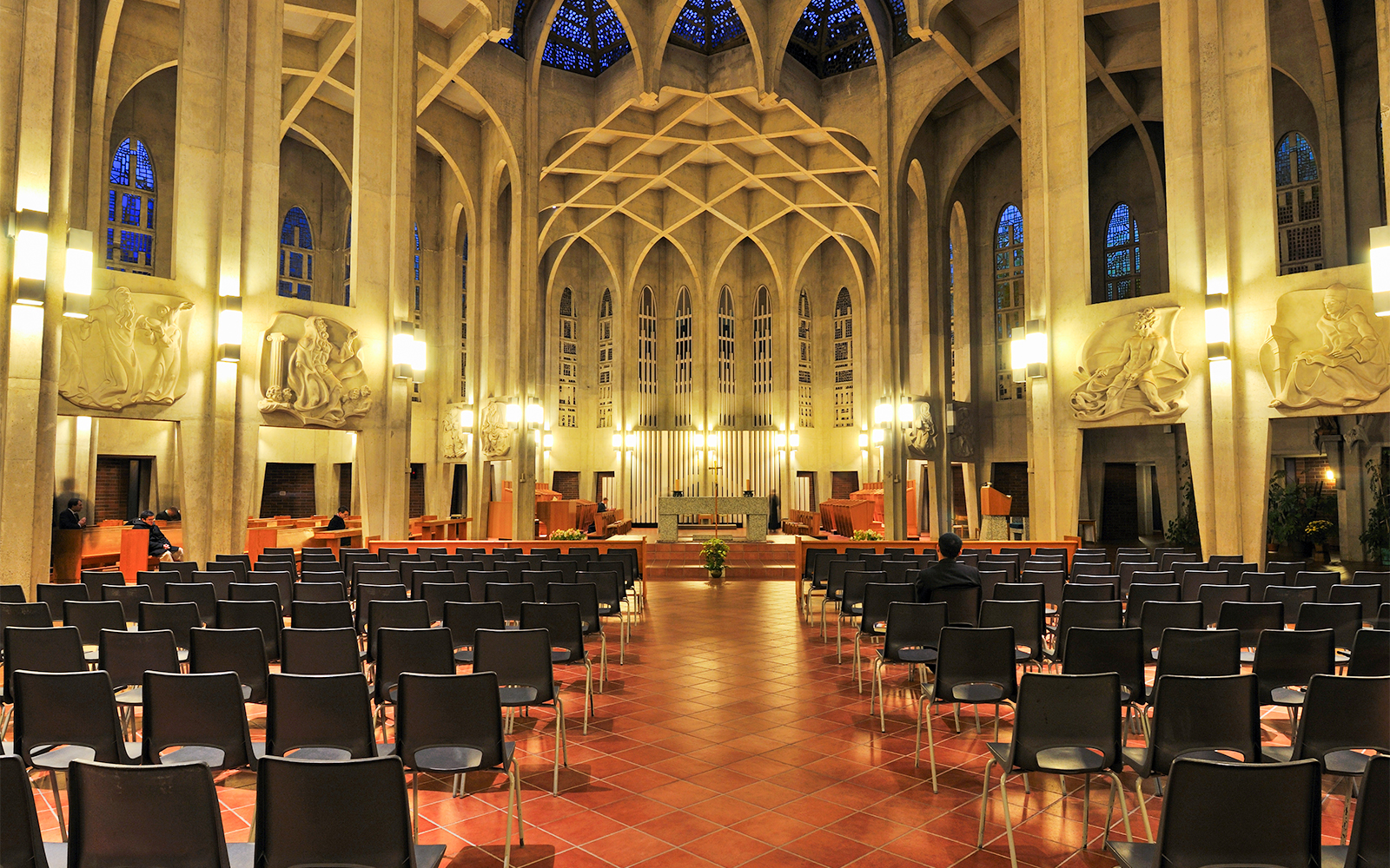 Interior of a cathedral with rows of chairs and ornate wall carvings, not Westminster Abbey.