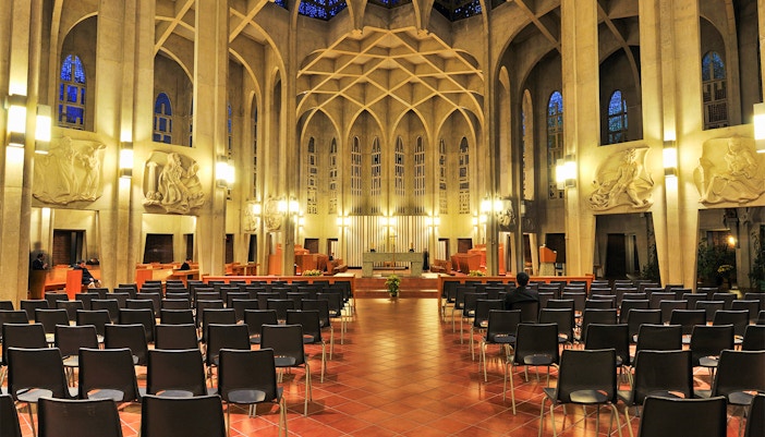 Interior of a cathedral with rows of chairs and ornate wall carvings, not Westminster Abbey.