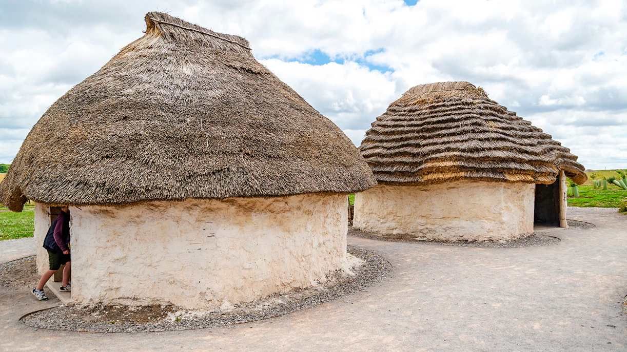 Traditional mud huts with thatched roofs at Stonehenge, England.