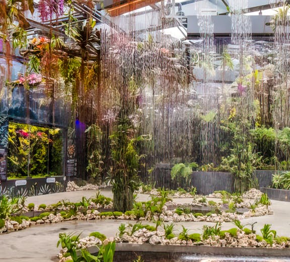 Indoor garden with hanging plants and water features at Floral Fantasy, Singapore.