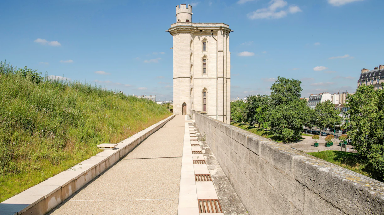 Château de Vincennes rooftop walkway with tower and city view.