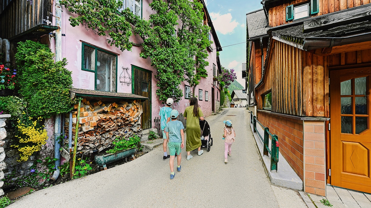 Family walking through a charming street in Hallstatt, Austria, during a day trip from Vienna.