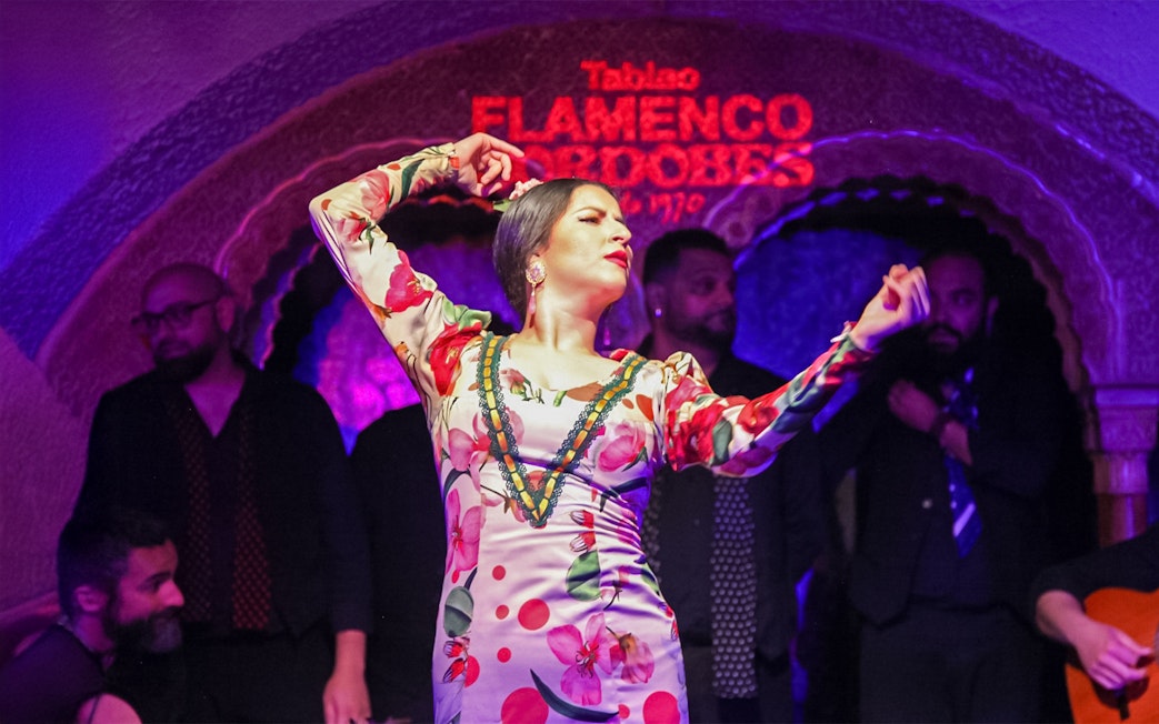 Flamenco dancer performing at Tablao Cordobes in vibrant dress.