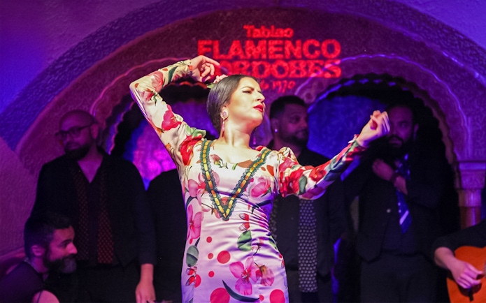 Flamenco dancer performing at Tablao Cordobes in vibrant dress.