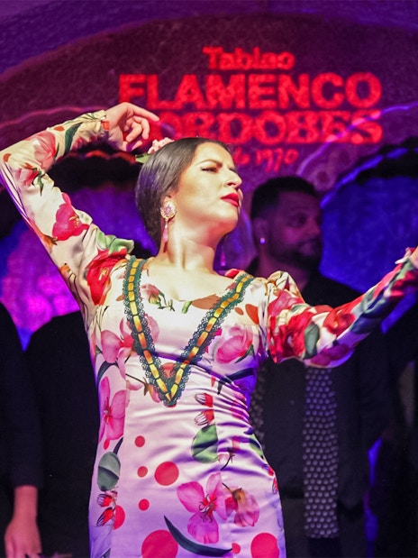 Flamenco dancer performing at Tablao Cordobes in vibrant dress.