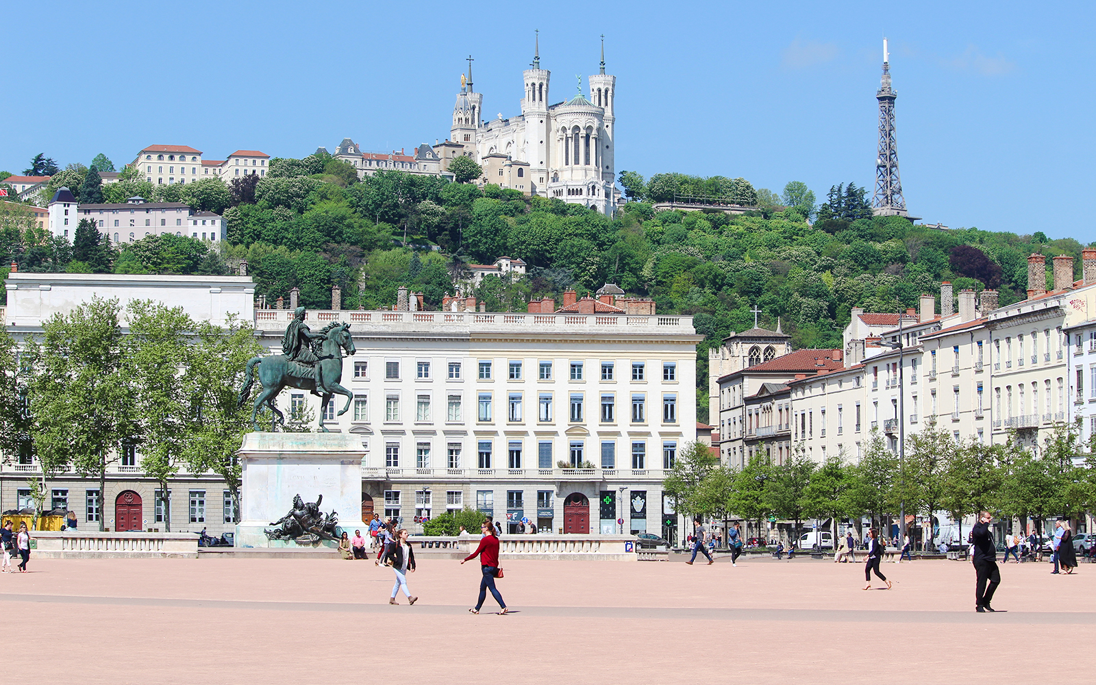 Place Bellecour in Lyon with equestrian statue and Basilica of Notre-Dame de Fourvière in the background.