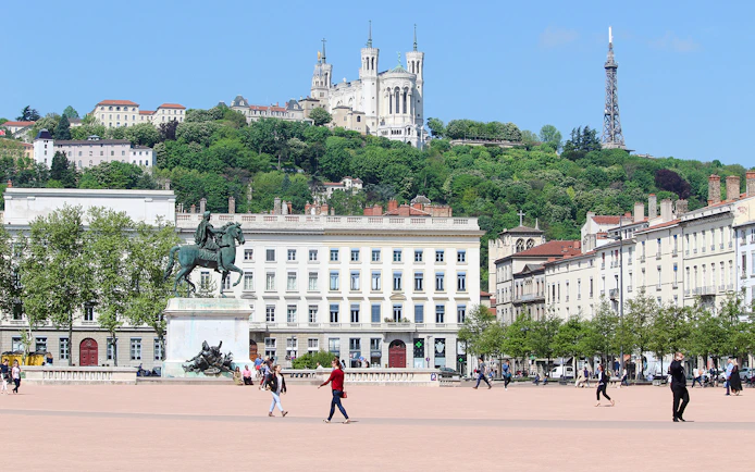 Place Bellecour in Lyon with equestrian statue and Basilica of Notre-Dame de Fourvière in the background.