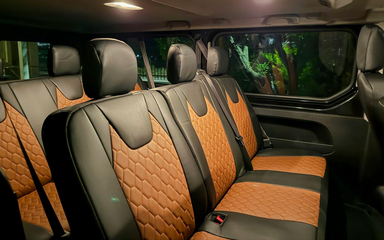 Interior of transfer van for Shipwreck Beach and Blue Caves tour, featuring leather seats.