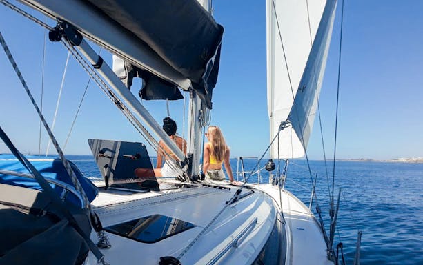 Tourists on a private boat enjoying Lisbon's coastal view.