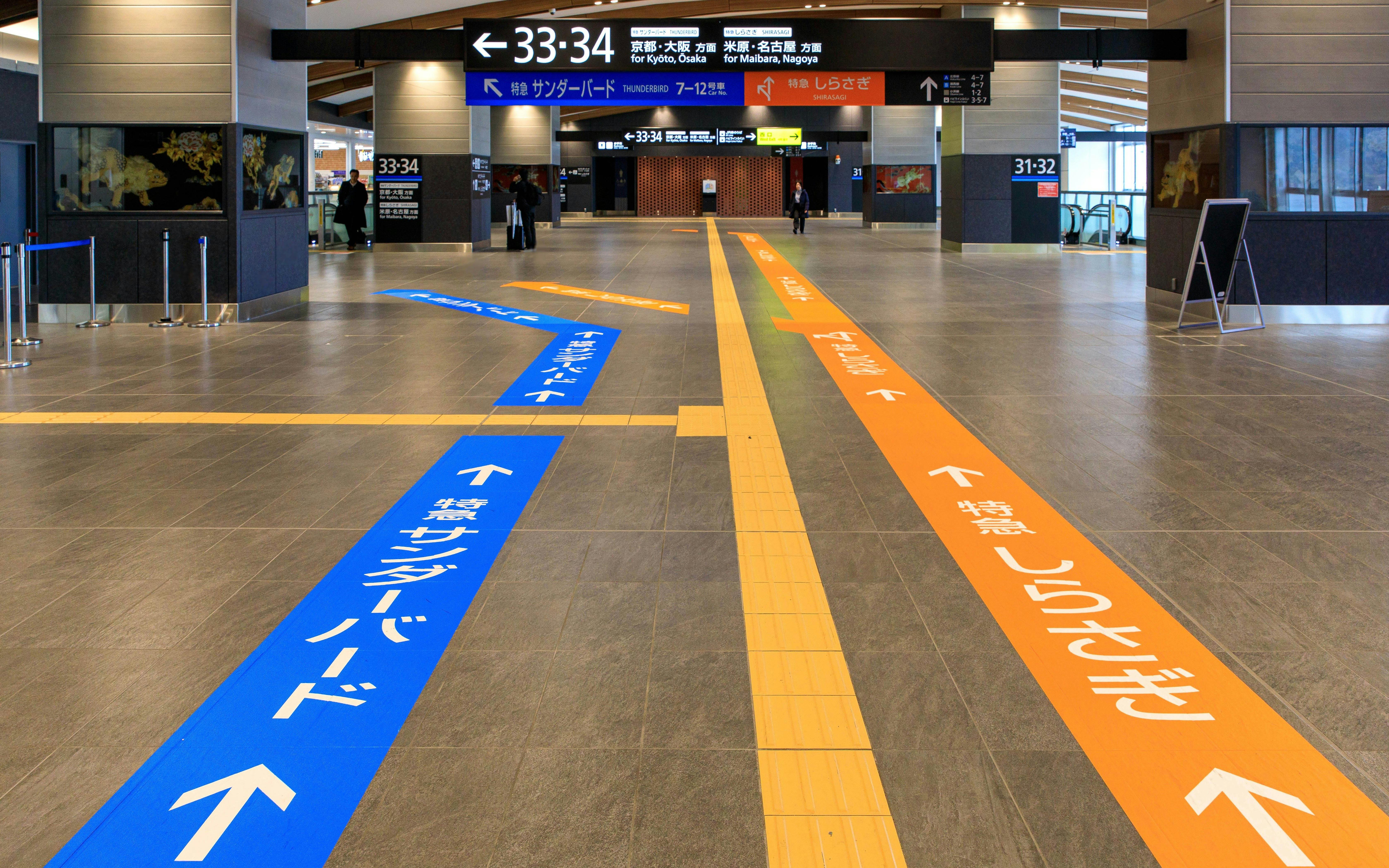Transfer guidance lines in Tsuruga Station concourse direct passengers to platforms.