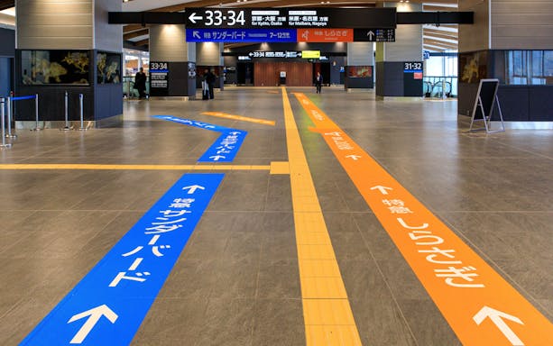 Transfer guidance lines in Tsuruga Station concourse direct passengers to platforms.