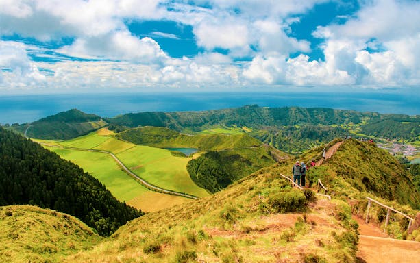 Hikers on a trail overlooking Sete Cidades crater lakes in Azores, Portugal.