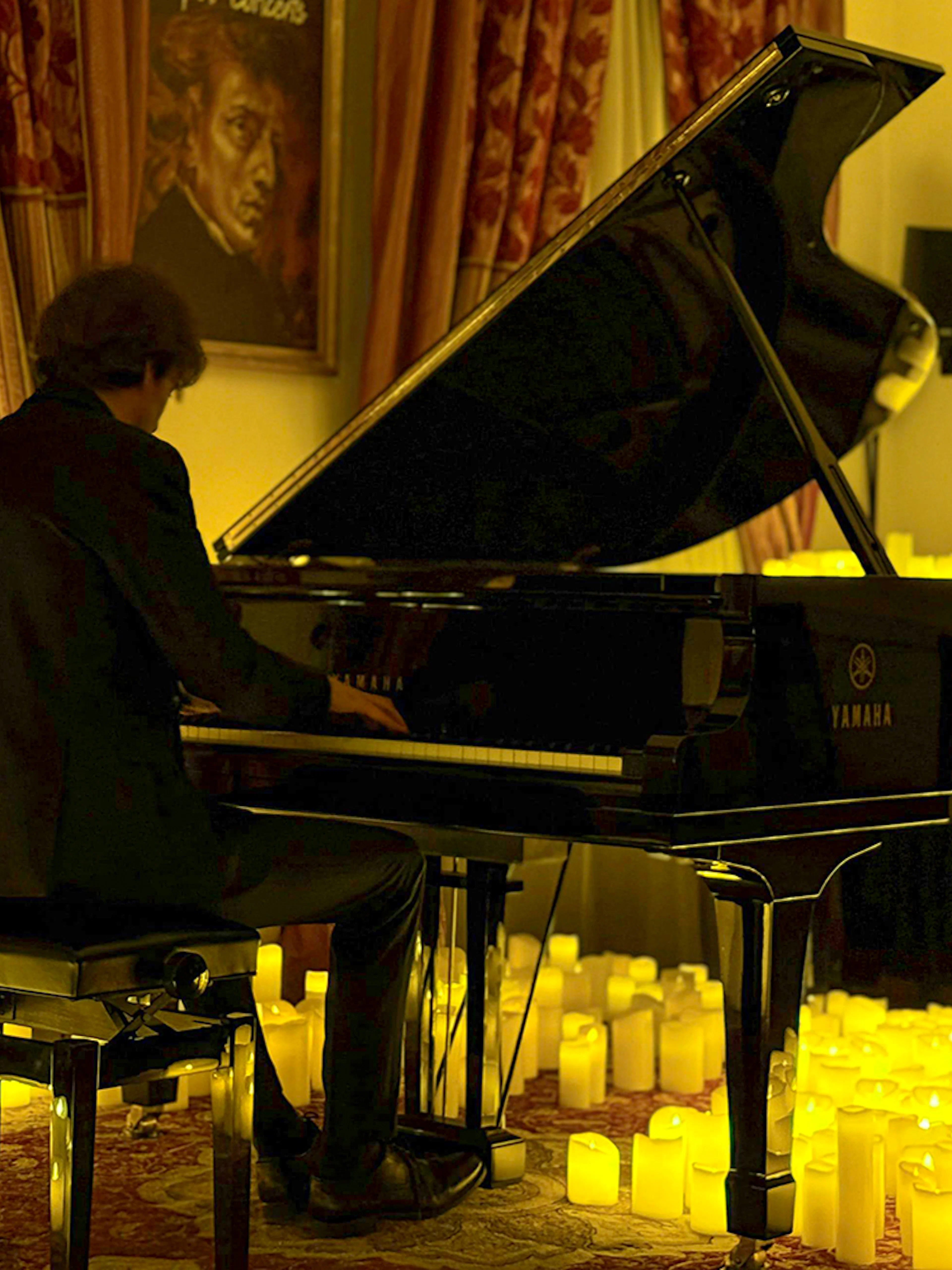 Pianist performing at candlelit Chopin concert, Chopin Gallery, Krakow.