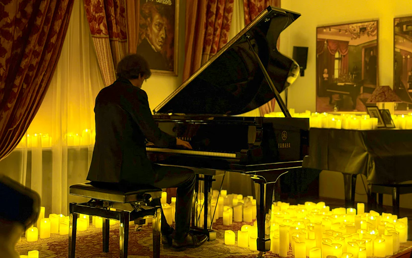 Pianist performing at candlelit Chopin concert, Chopin Gallery, Krakow.
