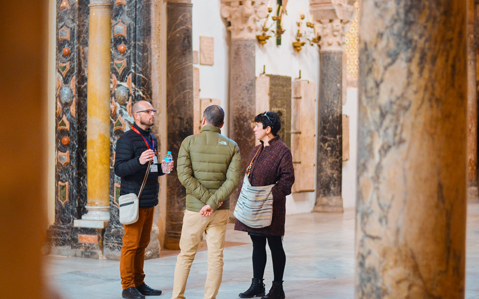 Guide explaining history to tourists inside Córdoba Mosque.