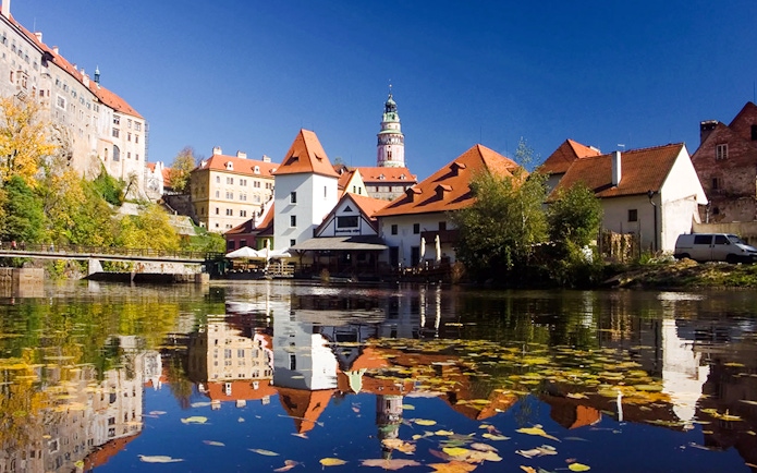Historic buildings reflected in the Vltava River, Český Krumlov, Czech Republic.