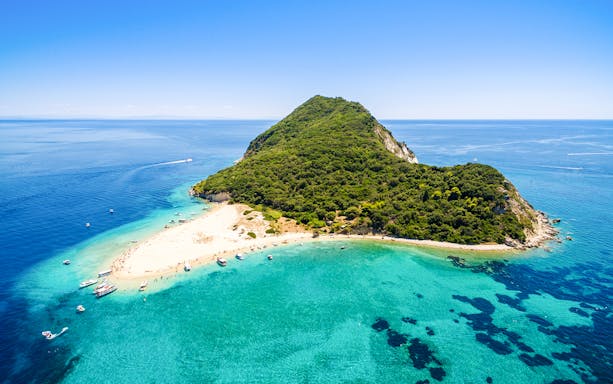 Aerial view of Marathonisi Island with sandy beaches and turquoise waters in Zakynthos, Greece.