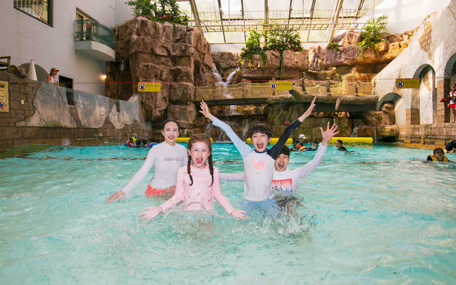 Kids playing in a pool at Caribbean Bay Water Park with waterfalls in the background.