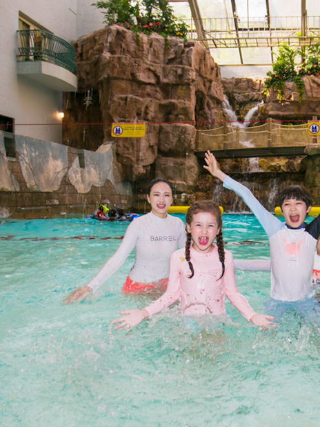 Kids playing in a pool at Caribbean Bay Water Park with waterfalls in the background.