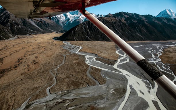 Aerial view of braided river and mountains from skiplane during Ultimate Alpine Experience in New Zealand.