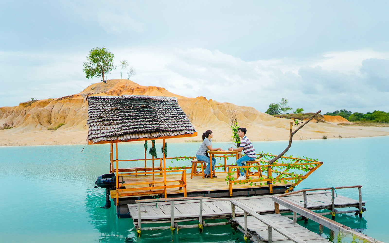 Couple on a boat at Blue Lake, Bintan Mini Desert in the background.