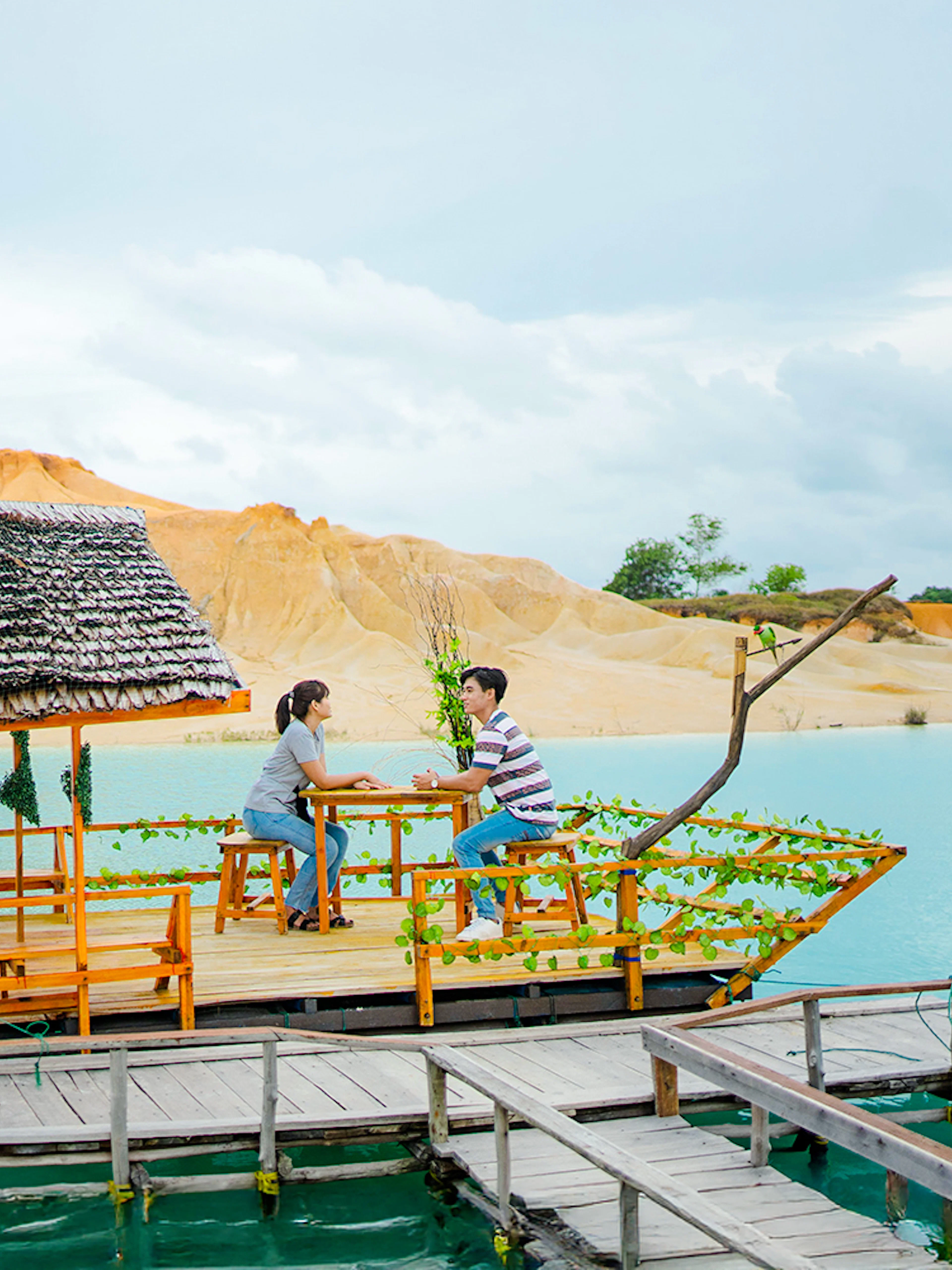 Couple on a boat at Blue Lake, Bintan Mini Desert in the background.