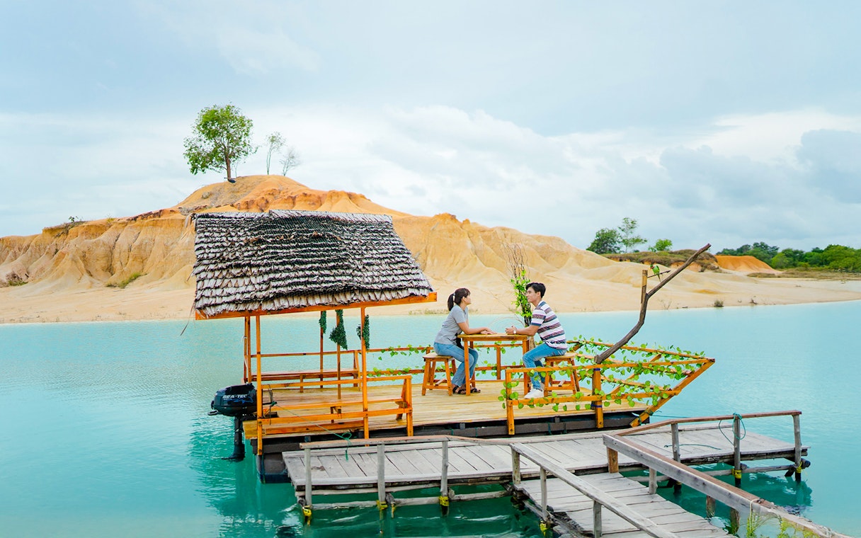Couple on a boat at Blue Lake, Bintan Mini Desert in the background.