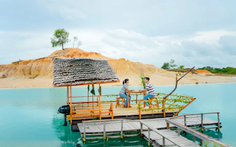 Couple on a boat at Blue Lake, Bintan Mini Desert in the background.