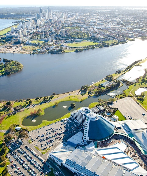 Aerial view of Perth's Optus Stadium and Swan River with city skyline.