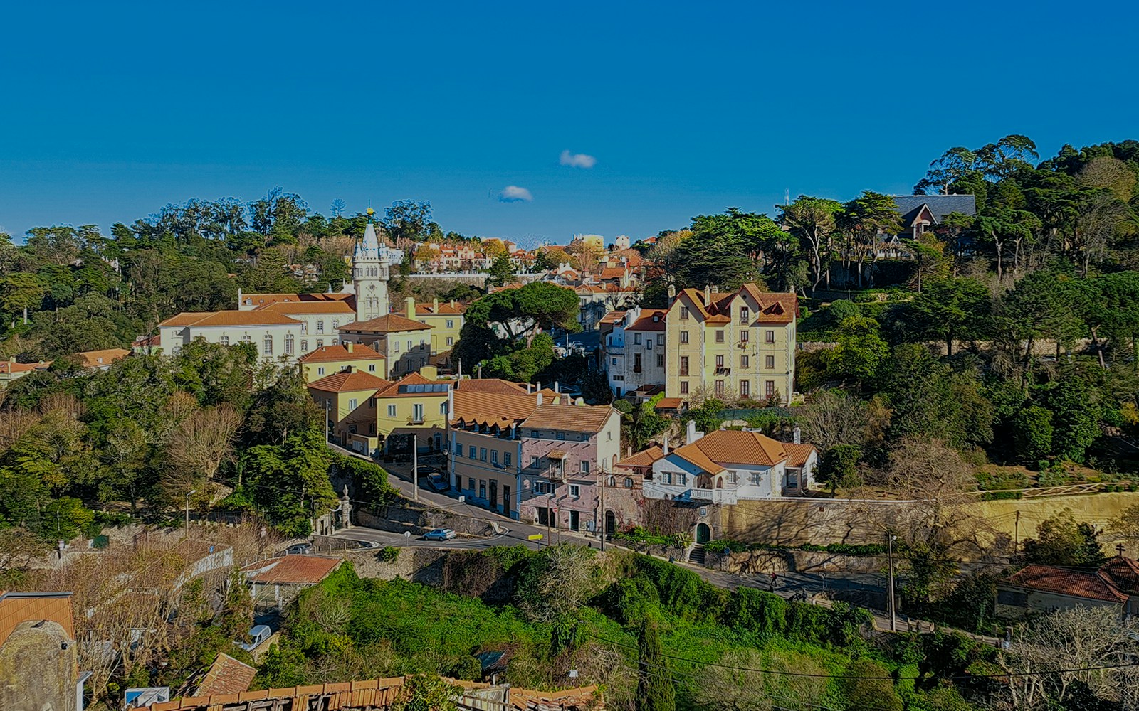 Sintra town road to Quinta da Regaleira, Portugal, surrounded by greenery and historic architecture.
