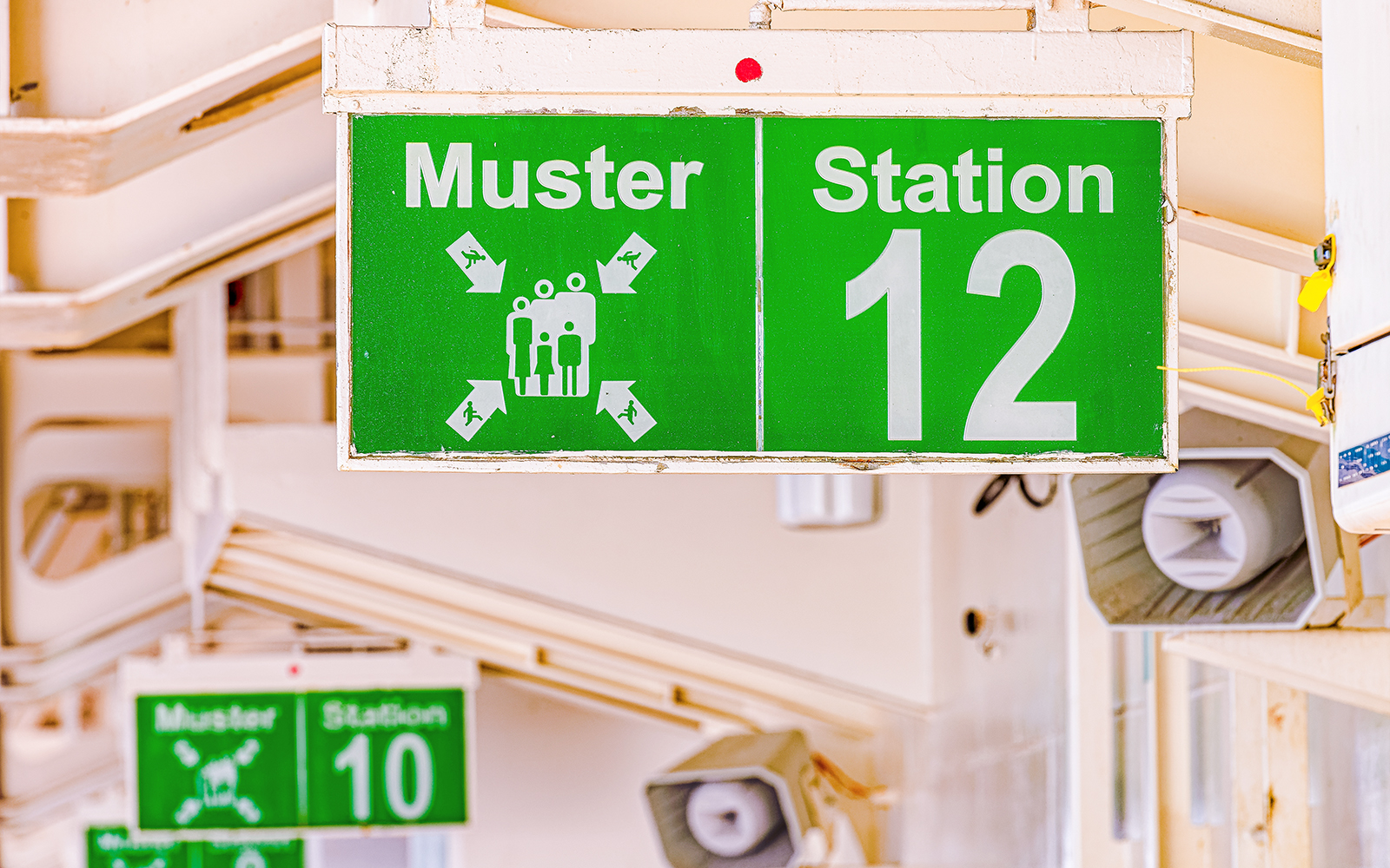 Cruise ship muster point sign indicating safety procedures.