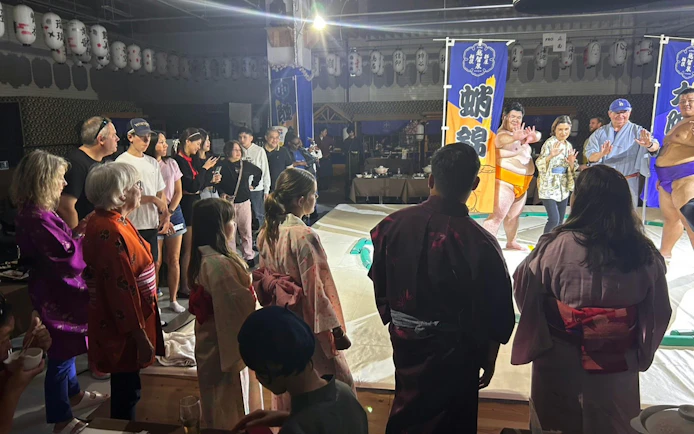 Sumo wrestlers and visitors at Ochiizumibeya during a practice show with Chanko-Nabe hot pot.