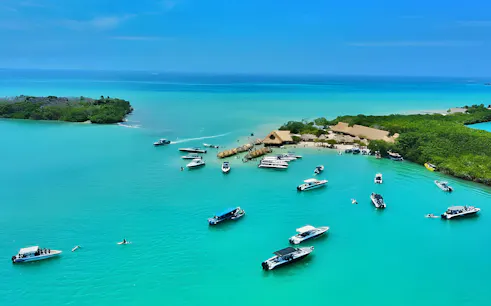 Boats on clear blue water near Rosario Islands, Cartagena, Colombia.