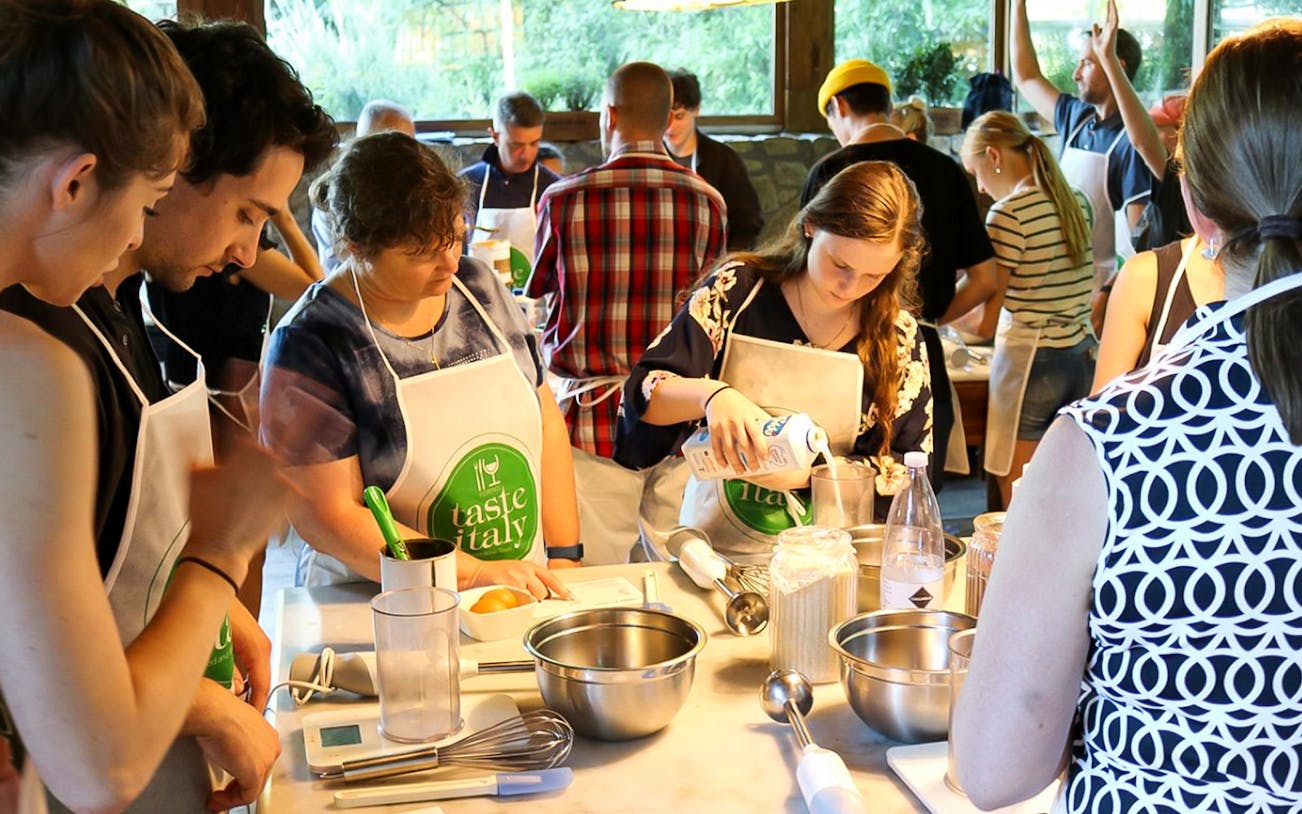 Participants in a cooking class preparing ingredients at a Tuscany farmhouse near Florence.