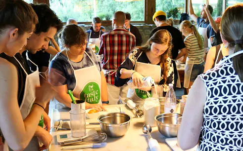 Participants in a cooking class preparing ingredients at a Tuscany farmhouse near Florence.